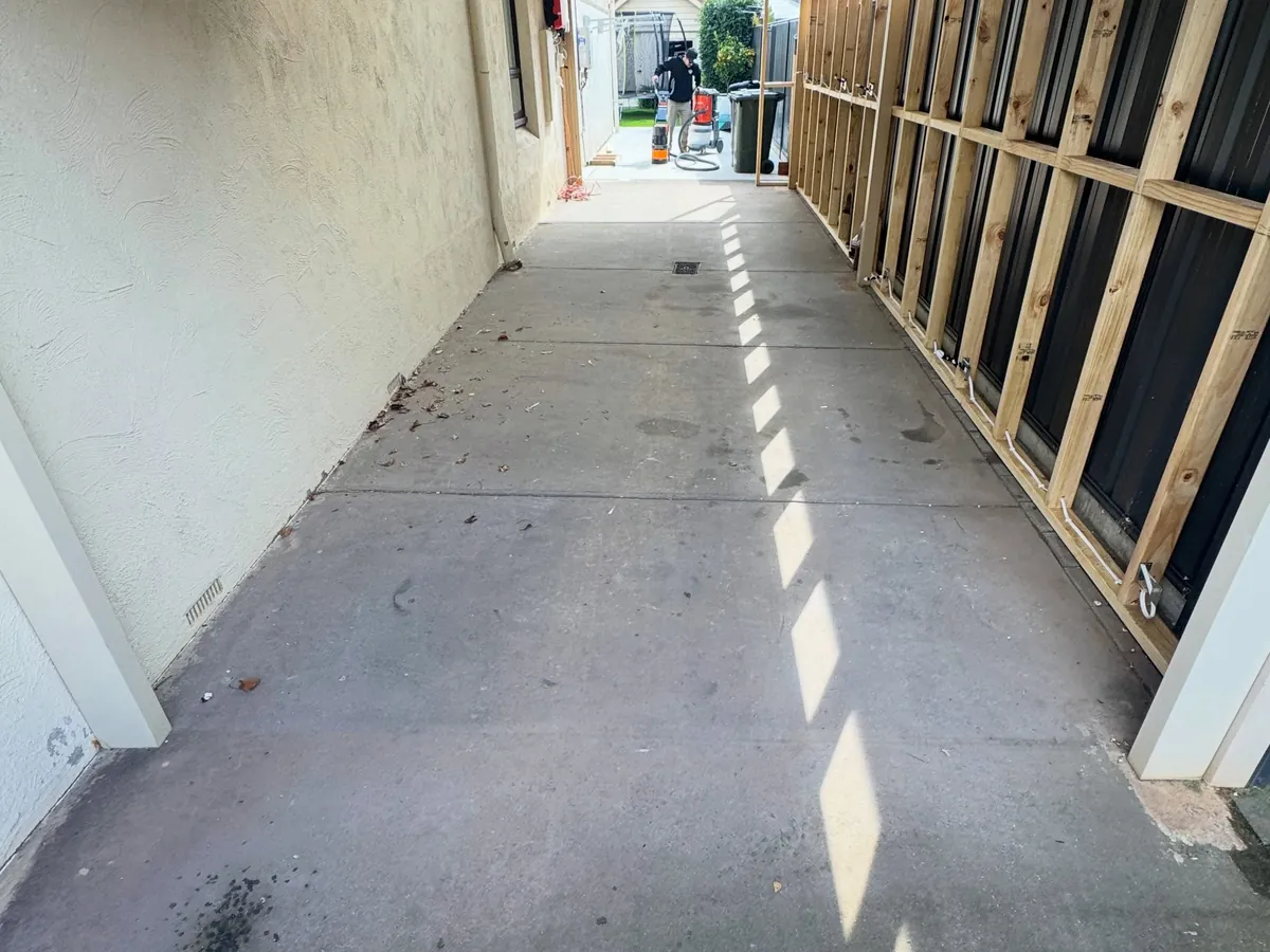 The same carport before coating — stained, marked bare concrete