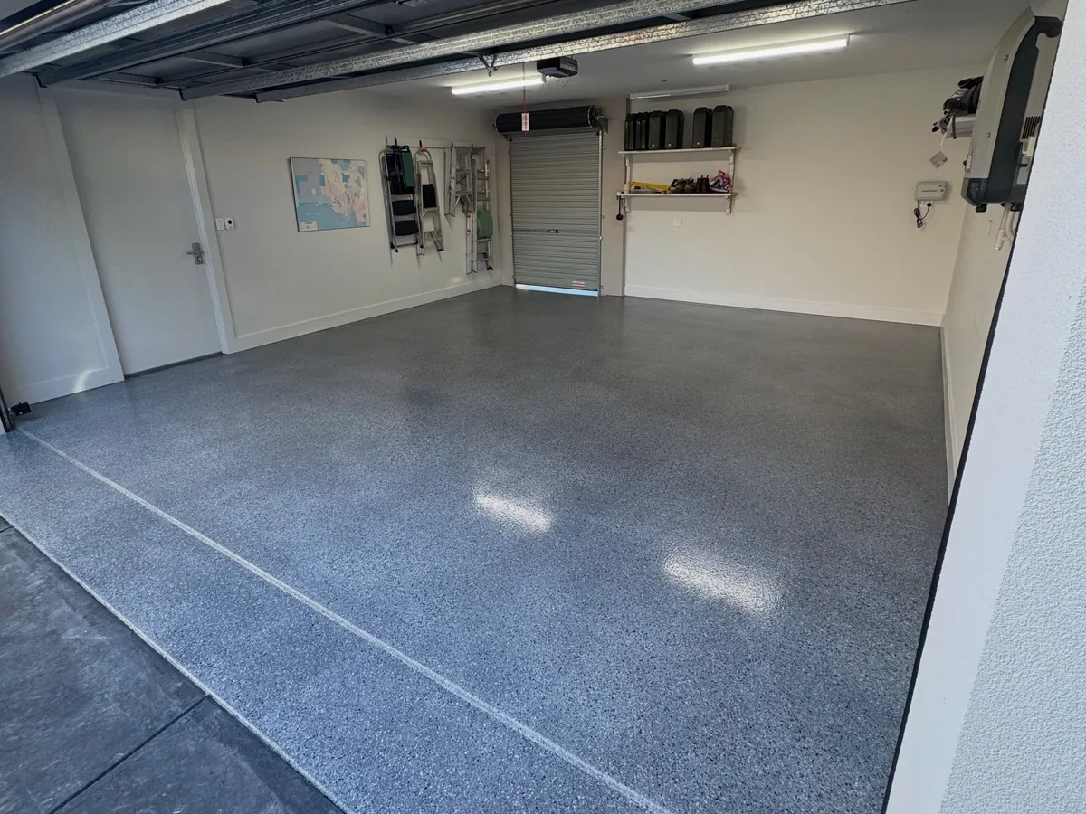 Double garage after coating — dark grey flake epoxy floor from the roller door to the back wall